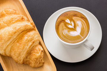 Cappuccino hot coffee latte art white cup and croissant 