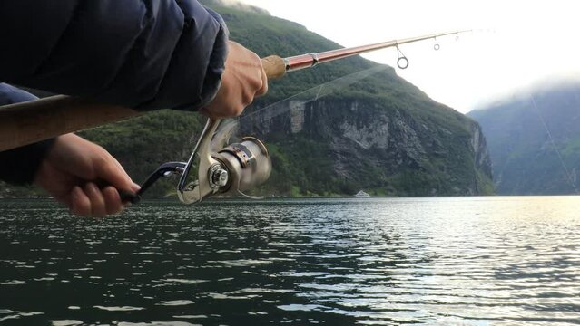 Woman fishing on Fishing rod spinning in Norway.