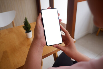 Mockup picture of business woman’s hands holding smart phone with white blank screen in modern place