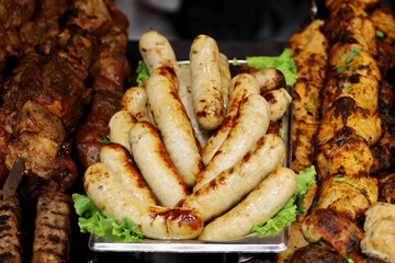 Sausages and kebab served with lettuce leaves, grilled meat