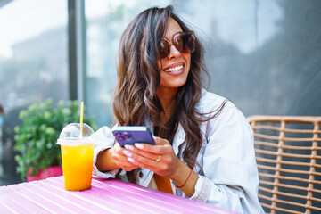 Portrait of happy young  woman with a laptop at cafe. Freelancer working on a laptop.  Business, online, education concept.