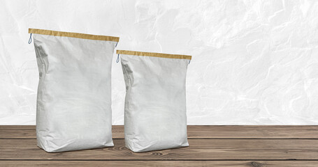 Paper bags set on wooden floor. Construction plaster cement sack isolated on white