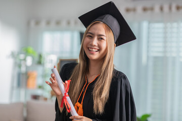Asian graduate in cap and gown smile and holding certificate or diploma proud of yourself,Graduated...