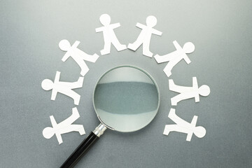 Magnifying glass with many paper human dolls around, search the right man for a business, talented...