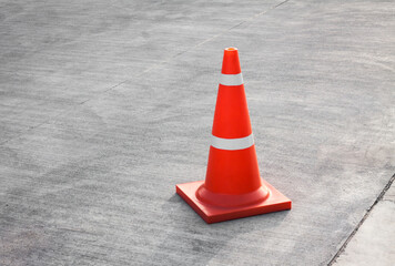 Striped orange cones on the asphalt road. Plastic orange cone on the road. Traffic cone on a...