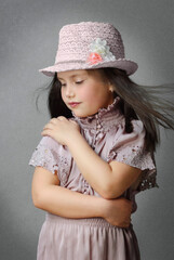 portrait of a little girl in a pink dress and hat