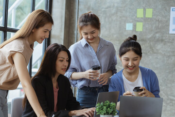 A group of young Asian business women stand and talk. Jointly open a startup company and a business plan management plan to grow the business and be profitable by the concept of the new generation.