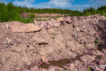 An abandoned quarry for the extraction of raspberry quartzite. Shoksha, Karelia. Russia