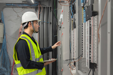 Electrical Engineer team working front control panel, An electrical engineer is installing and...