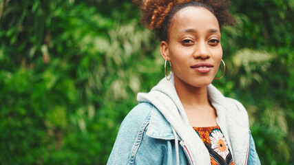 Closeup portrait African girl with ponytail wearing denim jacket, in crop top with national pattern...