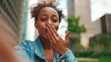 Closeup portret cute African girl with ponytail, wearing denim jacket makes stream, video call on...