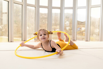 Little blonde girl with piggy tails playing with hula hoop