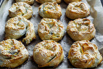 Twisted patties with dock and white cheese placed in the pan