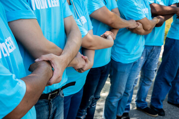 Volunteer putting their hands  together unity symbol during, stacked huddle together, achieve their ultimate goal. 