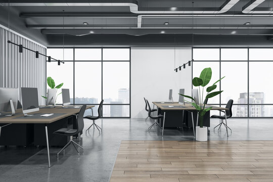 Side view on workspaces in coworking office with city view from big windows, wooden and concrete floor, green plants and modern computers on brown tables. 3D rendering
