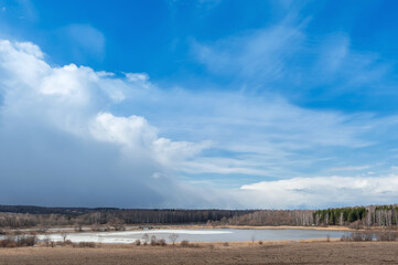 Spring landscape. Early spring. A lake with ice and beautiful thundery skies.