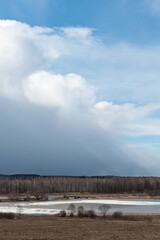 Spring landscape. Early spring. A lake with ice and beautiful thundery skies.