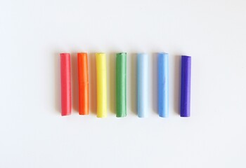 Multi-colored pastel crayons on a white background. Rainbow Colors. Art materials for school and hobbies.