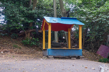 An old abandoned gazebo by the road in the countryside. Nearby is an electric pole and an old front...