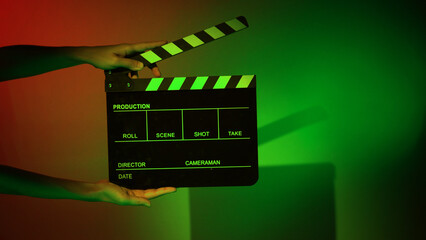 Fototapeta na wymiar Movie Clapper board. Crew hand holding plastic and wooden film slate board against camera. Movie clapperboard using in video production and movie studio works film industry. Film slate on crew hand.