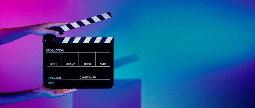 Movie Clapper board. Crew hand holding plastic and wooden film slate board against camera. Movie clapperboard using in video production and movie studio works film industry. Film slate on crew hand.