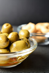 Seasoned green olives in a bowl.