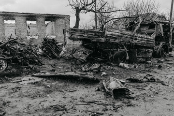 Burned car on the background of a destroyed house in the Ukrainian village