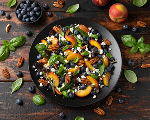 Peach, blueberry salad with vegetables, feta cheese and pecan nuts. Healthy summer food