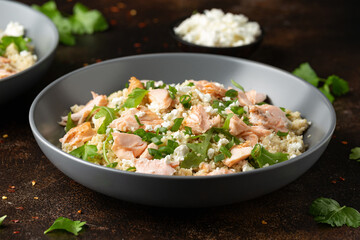 Salmon Couscous salad with feta cheese dressing and herbs. healthy food.