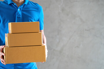 Delivery service courier man employee in blue t-shirt uniform holding empty cardboard boxes or parcel in hand.Copy space.Fast and free Delivery transport.Business Online shopping and Express delivery.