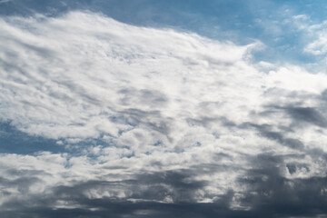 Obraz premium Dark clouds storm rain clouds with a gap where the sun shines view from below as a background.