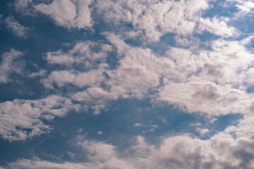 Red fluffy cumulus clouds on a blue sky close-up.