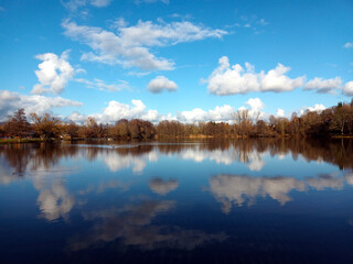 Wolken reflektieren sich im Noswendeler Stausee auf der Traumschleife Himmels Gääs Paad bei Noswendel im Landkreis Merzig-Wadern, Saarland. 