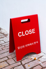 CLOSED sign board on street at korean restaurant.