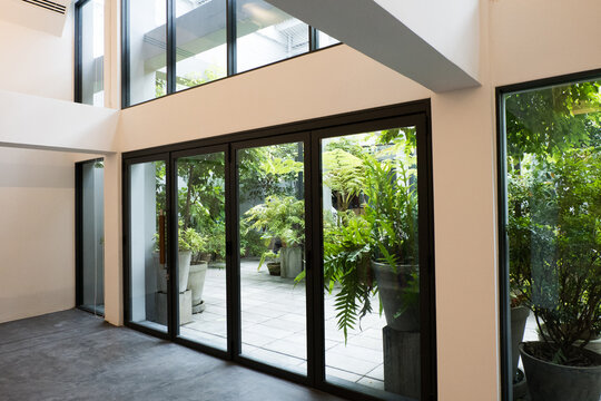 Fototapeta Slide glass window in modern empty room and overlooking the surrounding garden and forest.