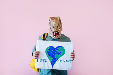 Man with lizard mask on pink background with sign that says save the planet.