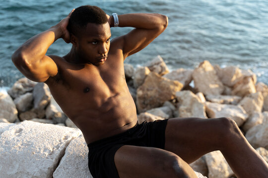 Athletic muscular african american man with bare chest, doing abdominal exercises