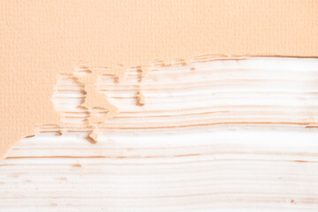 Cosmetic cream, body lotion applied on a beige background. Means for hygiene and care of white color.