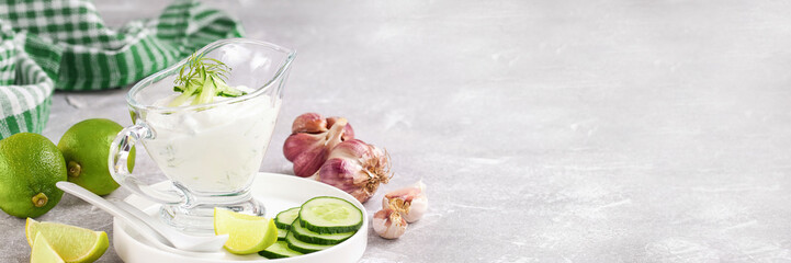 Tzatziki sauce in a glass sauce-boat. Ingredients for a dzadziki. Turkish dish cacik. Banner. Copy space