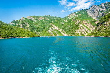 Fototapeta na wymiar Komani Lake ferry cruise boat view near the town of Fierz, Albania. Komani Lake is a popular tourist destination in Albania. 