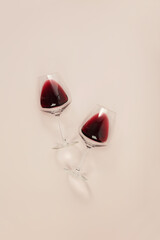 Flat-lay of red wine in glasses on pink background