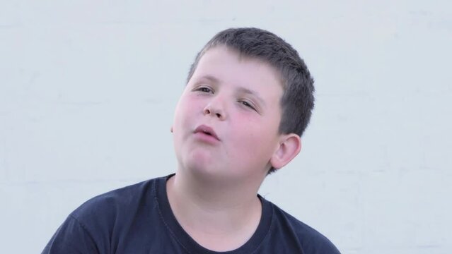 Overweight boy eats potato chips, close-up on the street. Unhealthy food
