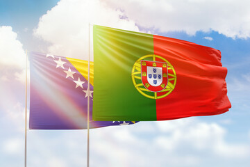 Sunny blue sky and flags of portugal and bosnia