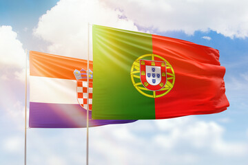 Sunny blue sky and flags of portugal and croatia