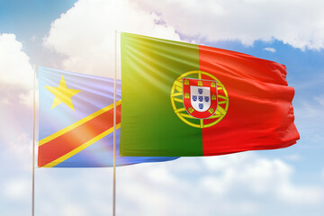 Naklejka premium Sunny blue sky and flags of portugal and dr congo