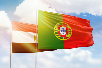 Sunny blue sky and flags of portugal and egypt
