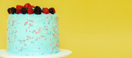 blue cake on yellow background Cake decorated with berries Birthday concept