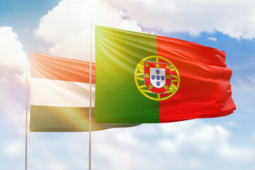 Sunny blue sky and flags of portugal and hungary