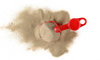 Beach toy for kids, plastic tool in sand pile isolated on white, top view