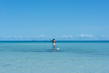 A man paddle boarding in the Caribbean Sea near Isla Mujeres beach in Mexico